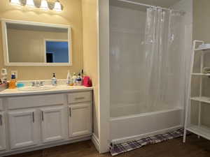 Full bathroom with vanity, shower / bath combo with shower curtain, and wood finished floors