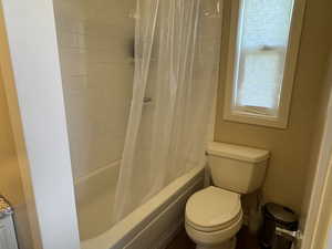 Full bath with shower / bathtub combination with curtain and toilet