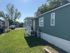 View of property exterior with a yard and a chimney