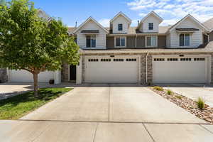 View of front of house featuring driveway and stone siding