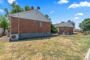 View of side of property with brick siding and a chimney