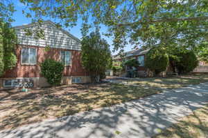 View of side of home featuring brick siding and a yard