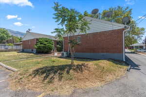View of property exterior with brick siding and a mountain view