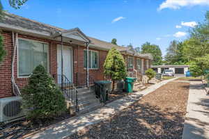 Entrance to property with roof with shingles and brick siding