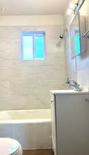 Bathroom with vanity and shower / washtub combination