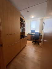 Home office with light wood-style floors and recessed lighting