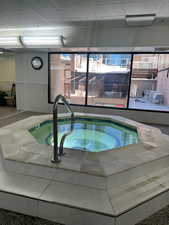 View of swimming pool with a hot tub