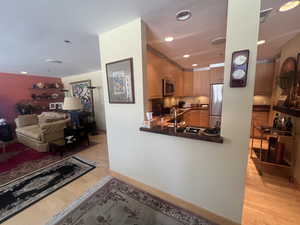 Kitchen with light wood-style floors, dark countertops, recessed lighting, appliances with stainless steel finishes, and open floor plan