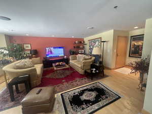 Living area with wood finished floors and recessed lighting