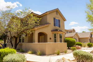 View of front of property featuring a tiled roof, a fenced front yard, and stucco siding