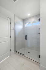 Bathroom with a stall shower and tile patterned floors