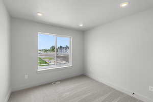 Carpeted empty room featuring baseboards and recessed lighting