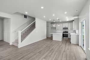 Kitchen with light countertops, stainless steel appliances, decorative backsplash, recessed lighting, and open floor plan