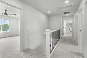 Hallway with carpet, attic access, and recessed lighting