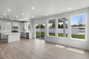 Kitchen with light wood-style floors, light countertops, recessed lighting, a kitchen island, and stainless steel appliances