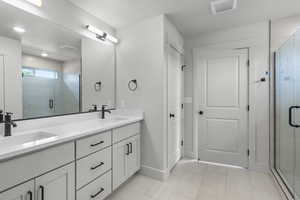 Full bathroom featuring double vanity, a shower stall, and tile patterned flooring