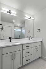 Bathroom with double vanity, a shower stall, and tile patterned flooring