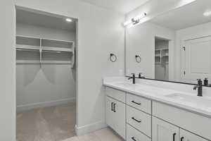 Full bathroom featuring double vanity, a spacious closet, recessed lighting, and tile patterned flooring