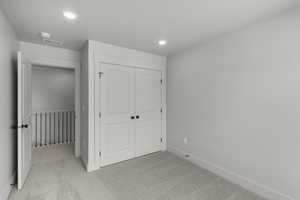 Unfurnished bedroom with light colored carpet, recessed lighting, and a closet