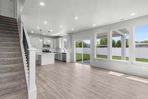 Unfurnished living room featuring stairs, recessed lighting, and light wood-style floors