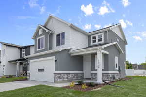 View of front of house featuring an attached garage, a front yard, stucco siding, and driveway