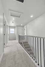 Hallway featuring attic access, carpet, and recessed lighting