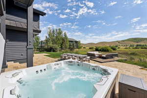 View of pool featuring a patio, a hot tub, and a mountain view