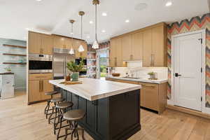 Kitchen featuring decorative light fixtures, light brown cabinetry, light wood-type flooring, and recessed lighting