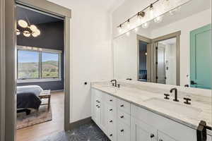 Ensuite bathroom featuring double vanity and a chandelier