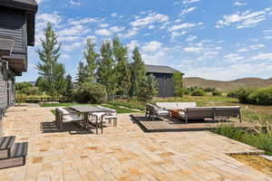 View of patio featuring a mountain view, outdoor dining space, and an outdoor hangout area