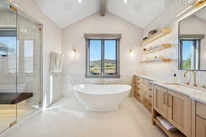 Full bathroom featuring a freestanding bath, a stall shower, vanity, tile walls, and light tile patterned floors