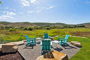View of yard with a patio, an outdoor fire pit, and a mountain view