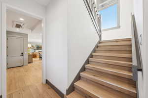 Stairway featuring cooling unit, hardwood / wood-style flooring, and recessed lighting