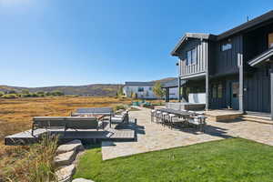 View of grassy yard featuring a patio area, an outdoor living space, outdoor dining area, and a balcony