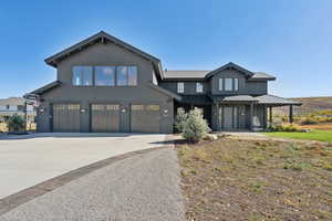 View of front facade featuring driveway, an attached garage, and board and batten siding