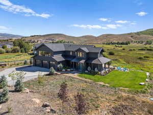 View of front of house with concrete driveway, a metal roof, a mountain view, and a garage