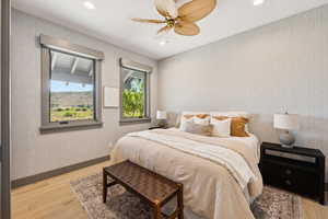 Bedroom with light wood finished floors, wallpapered walls, recessed lighting, and a ceiling fan