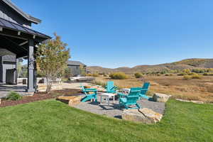 View of grassy yard featuring a patio and a mountain view