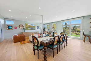 Dining area featuring light wood finished floors, recessed lighting, and wooden walls