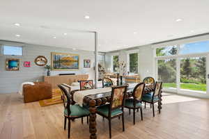 Dining room with light wood-style floors, recessed lighting, and wooden walls