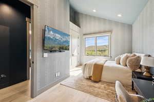Bedroom featuring wallpapered walls, light wood-style floors, and recessed lighting