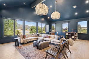 Living area featuring recessed lighting, light wood-style flooring, a chandelier, high vaulted ceiling, and a mountain view