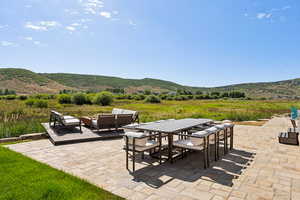 View of patio / terrace with outdoor dining space, a mountain view, and an outdoor hangout area