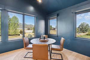 Dining area featuring plenty of natural light, wood finished floors, and a mountain view