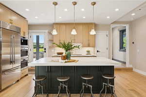 Kitchen featuring appliances with stainless steel finishes, recessed lighting, decorative light fixtures, and light brown cabinets