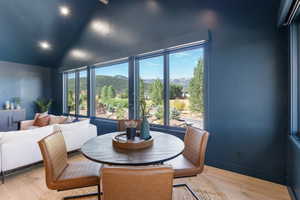 Dining room featuring a mountain view, light wood-type flooring, plenty of natural light, high vaulted ceiling, and recessed lighting