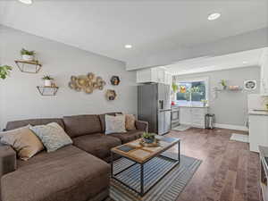 Living room with light wood finished floors and recessed lighting