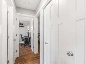 Corridor with dark wood-type flooring and a desk