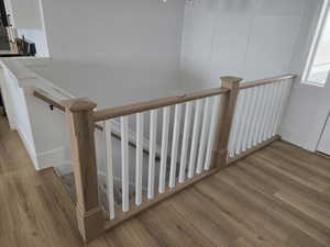 Staircase featuring wood finished floors and a decorative wall