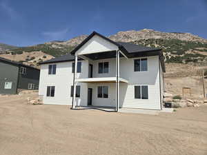 Rear view of property featuring a mountain view, board and batten siding, and a patio